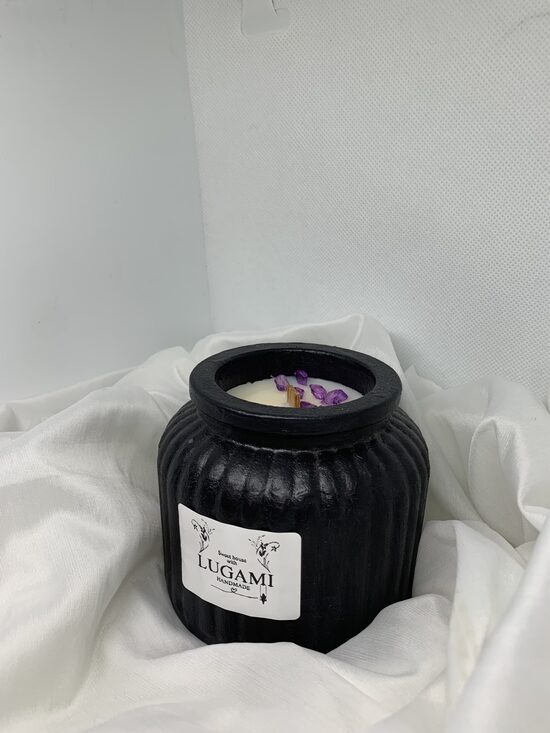 Žvakė su akmenukais juodame indelyje